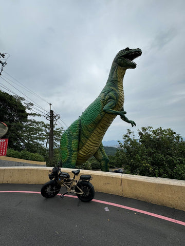 UDX 電輔車與中和烘爐地大恐龍地標合照，展示復古電輔胖胎車的越野冒險風格與山路實測紀實