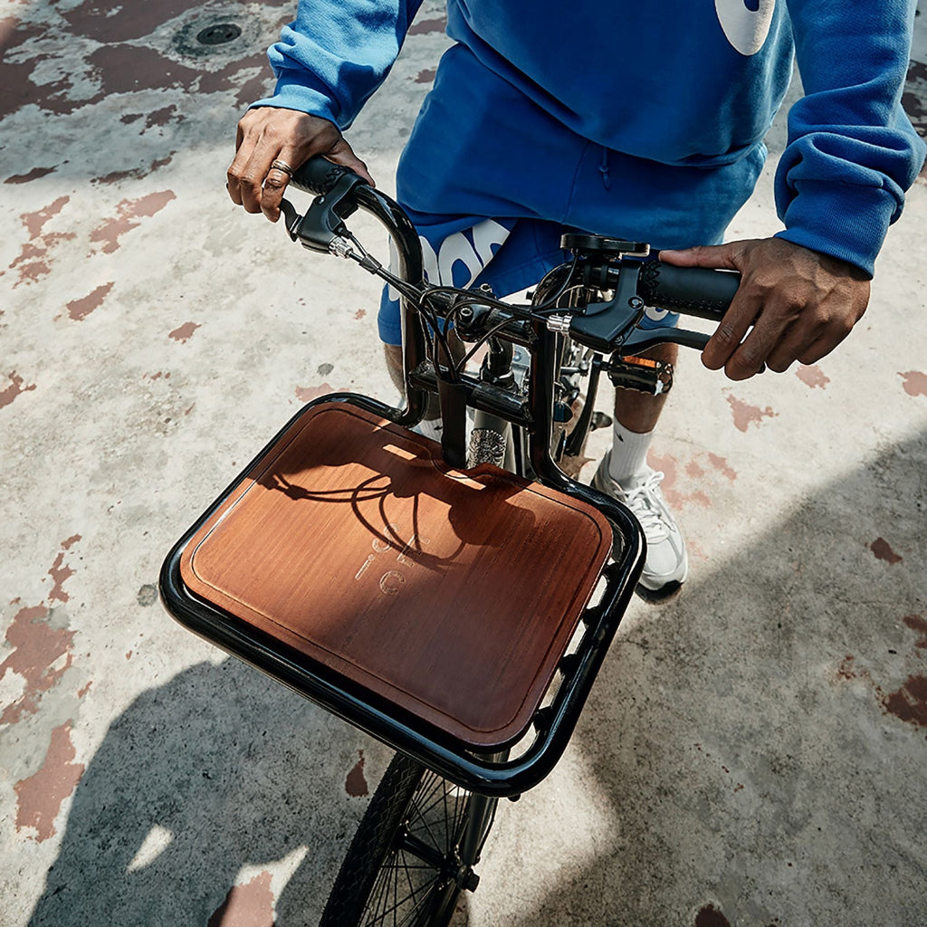 一名男子騎著 SEic miniu 山貓石英灰，車上安裝前貨架以及專用木底板，添增質感也兼顧實用