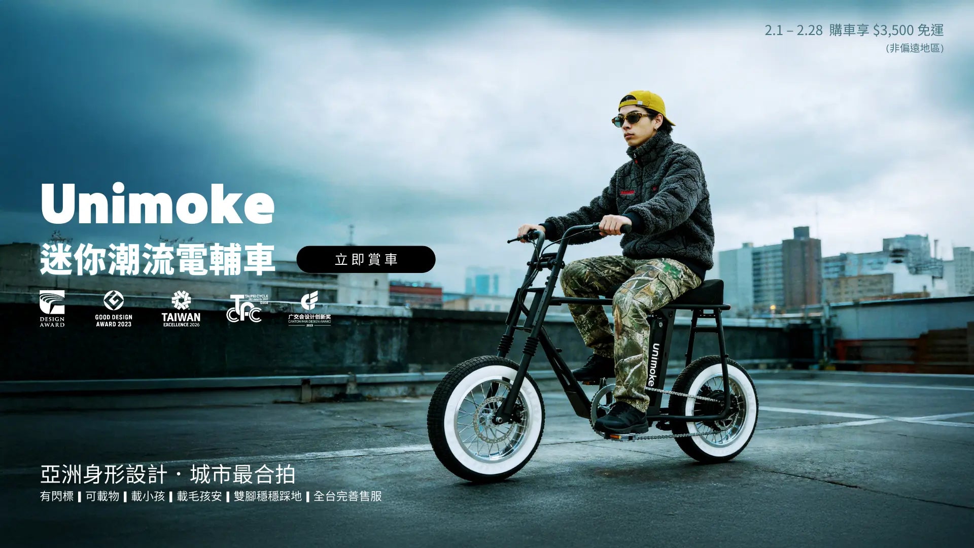 Unimoke 迷你潮流電輔車，黑色車身白色輪胎，一名男子穿迷彩褲、黑色抓毛外套、黃色帽子與墨鏡騎行於都市屋頂，呈現現代電動自行車潮流生活與設計感