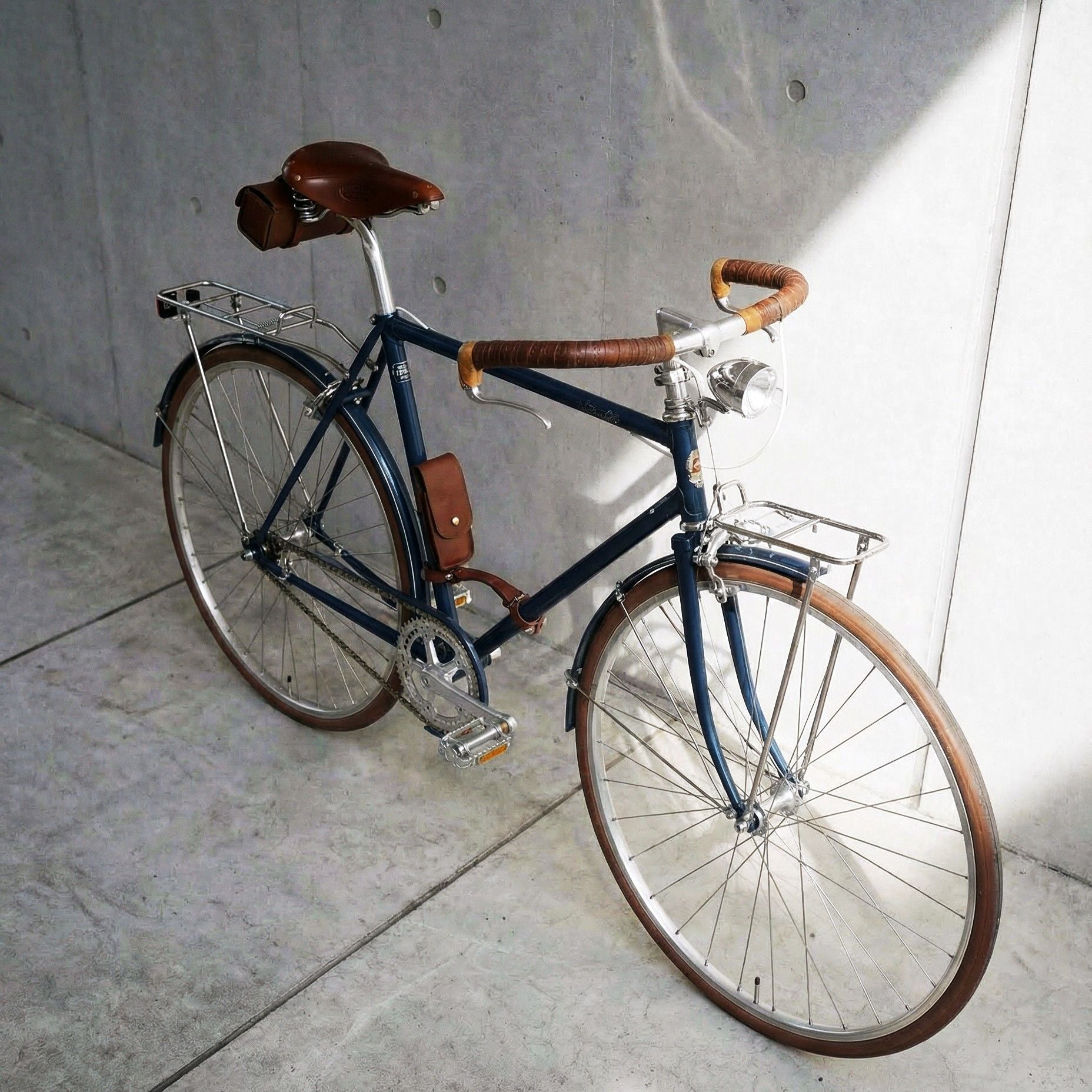 一台深藍色瑞士復古鋼管車，搭載全配備設定，日常所需一次到位，陽光灑在車頭和真皮手握，復古質感一眼可見。